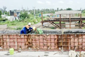 Construction of the overpass on Ring Road 3 across Nguyen Van Bua Street in Xuan Thoi Son and Xuan Thoi Thuong communes of Hoc Mon District in HCMC (Photo: SGGP)