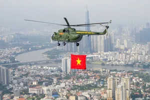 A helicopter carrying the Vietnamese national flag flies over the skies of HCMC, creating an impressive highlight for the military parade on April 30, 2025 (Photo: SGGP)