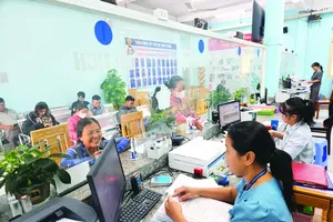 A civil servant of An Phu Dong Ward in District 12 of HCMC is processing administrative papers for residents (Photo: SGGP)