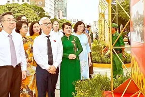 Deputy Secretary Nguyen Thanh Nghi of the HCMC Party Committee and Head Nguyen Van Loi of the HCMC National Assembly Delegation are appreciating the photo exhibition “The Glorious 80 Years of the Vietnamese National Assembly” on August 7 (Photo: SGGP)