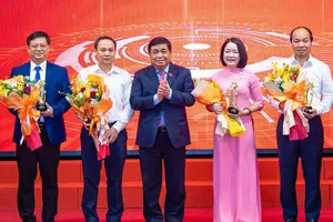 Deputy Prime Minister Nguyen Chi Dung is presenting flowers and commemorative medals to collectives and individuals for their outstanding achievements in digital transformation