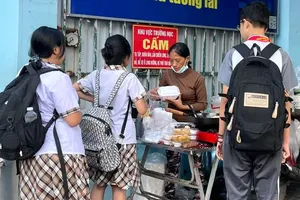Street vendors selling in front of the gate of Huynh Tan Phat Junior High School in Tan Thuan Ward (Photo: SGGP)