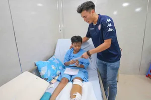 Thủ môn Bùi Tiến Dũng tặng quà cho các em học sinh trường THCS Bạch Đằng trong vụ cây phượng bật gốc. Ảnh: Dũng Phương