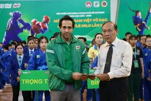 Đại diện BTC giải Vovinam trao quà đại diện trường THCS Bạch Đằng hỗ trợ cho gia đình em Nguyễn Trung Kiên. Ảnh: Dũng Phương