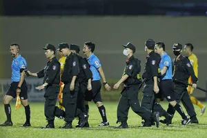 Lực lượng CSCĐ phải vào sân bảo vệ tổ trọng tài từ những phản ứng của cầu thủ CLB TPHCM. Ảnh: THANH ĐÌNH