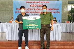 Đại diện Qũy Phát triển Tài năng Việt – cầu thủ Công Phượng trao bảng tượng trưng quà tặng cho Thượng tá Lê Viết Tiệp – Chánh văn phòng Đảng ủy CATP, Trưởng phòng Công tác Đảng và Công tác Chính trị