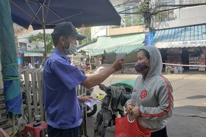 Từ 6 giờ sáng 9-5, Ban quản lý chợ Đống Đa bố trí 3 cổng vào chợ với đầy đủ lực lượng bảo vệ, triển khai yêu cầu người dân trình phiếu đi chợ, sát khuẩn và đeo khẩu trang trước khi vào