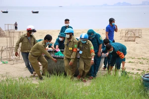 Lực lượng chức năng hỗ trợ ngư dân đưa thuyền thúng lên bờ