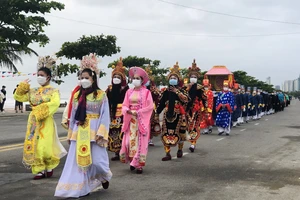 Đoàn rước trong trang phục áo dài, khăn đóng cùng kiệu rước, đội dâng hoa quả tiến về lễ đài chính thực hiện nghi thức cầu an, cầu ngư