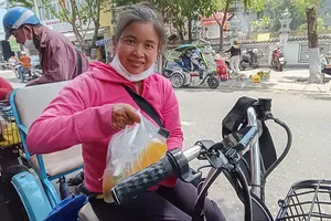Trao bữa trưa đến một người lao động giữa trưa nắng gắt. Ảnh: XUÂN QUỲNH