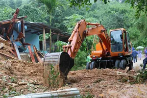 Lực lượng Quân khu 5 sử dụng phương tiện cơ giới khắc phục điểm sạt lở, thông tuyến đường bị chia cắt do mưa lớn. Ảnh XUÂN QUỲNH