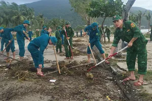 Lực lượng chức năng dọn rác tấp đầy đường ven biển Sơn Trà sau bão số 13. Ảnh: XUÂN QUỲNH