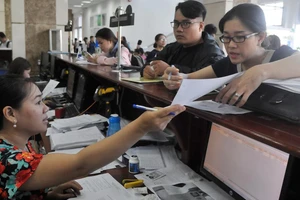 Doanh nghiệp nêu thắc mắc với nhân viên Cục Thuế TPHCM. Ảnh: CAO THĂNG