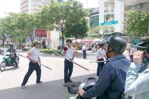 Đội trật tự học đường của Trường THPT chuyên Lê Hồng Phong (TPHCM) tham gia điều phối giao thông trước cổng trường giờ tan học. Ảnh: THU HƯỜNG