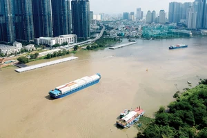 Sà lan vận chuyển hàng hóa trên sông Sài Gòn qua khu vực trung tâm TPHCM. Ảnh: CAO THĂNG