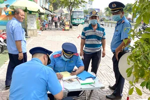 Thanh tra GTVT lập biên bản vi phạm quy định về đảm bảo trật tự an toàn giao thông trên đường Kinh Dương Vương, quận Bình Tân. Ảnh: CAO THĂNG