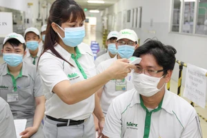 Đo thân nhiệt trước khi tiêm vaccine Covid-19 cho nhân viên Công ty Nidec (Khu công nghệ cao TPHCM). Ảnh: HOÀNG HÙNG