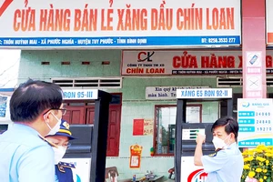 Đoàn kiểm tra Cục QLTT Bình Định kiểm tra đột xuất tại cửa hàng xăng dầu bán lẻ trên địa bàn. Ảnh: XUÂN HUYÊN