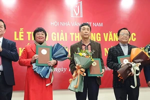 Đồng chí Nguyễn Trọng Nghĩa (bìa trái) và nhà thơ Nguyễn Quang Thiều trao Giải thưởng Văn học 2021 của Hội Nhà văn Việt Nam