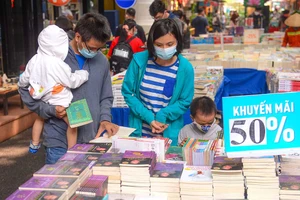 Mẹ và con cùng chọn mua sách. Ảnh: DŨNG PHƯƠNG