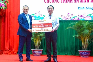 Ông Nguyễn Đăng Thanh – Phó Tổng Giám đốc HDBank (trái) trao tặng kinh phí xây dựng 100 căn nhà đại đoàn kết, ông Lữ Quang Ngời - Chủ tịch UBND tỉnh Vĩnh Long đại diện nhận