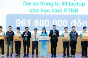 Thầy Nguyễn Thanh Hùng (áo sơ mi trắng) và một số cựu học sinh trao tặng laptop cho Trường Phổ thông Năng khiếu. Ảnh: V.H.