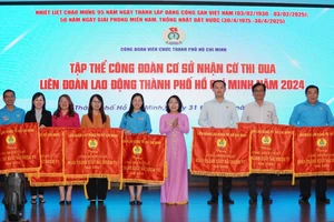 Phó Bí thư Đảng ủy Khối Dân – Chính – Đảng TPHCM Hàng Thị Thu Nga trao cờ thi đua của LĐLĐ TPHCM đến các tập thể