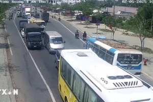 Các dòng xe ô tô "rồng rắn" nối đuôi nhau trên Quốc lộ 60 để di chuyển qua cầu Rạch Miễu vào lúc 10 giờ 56 phút, ngày 2-5. Ảnh: TTXVN