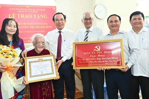 Bí thư Thành ủy TPHCM Nguyễn Văn Nên trao Huy hiệu 80 năm tuổi Đảng đến đồng chí Nguyễn Thị Thanh Bình. Ảnh: VIỆT DŨNG