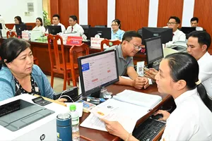 Hướng dẫn người dân làm thủ tục hành chính tại Trung tâm dịch vụ hành chính công phường Tam Bình, TPHCM. Ảnh: VIỆT DŨNG