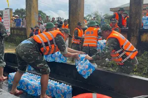 Cán bộ, chiến sĩ Quân khu 5 đưa nhu yếu phẩm đến người dân vùng ngập sâu tại xã Đại Lộc (TP Đà Nẵng). Ảnh: XUÂN QUỲNH