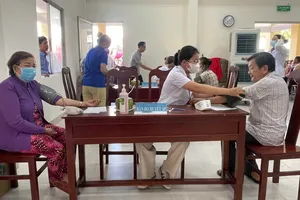 Đồng Chí Huỳnh Thành Đạt trao quà cho người có công xã An Định, tỉnh Vĩnh Long. Ảnh: MINH TÂM