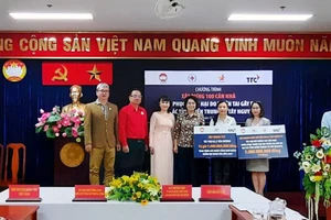 Trao bảng tượng trưng tài trợ xây dựng 100 căn "Nhà đoàn kết yêu thương". Ảnh: HOÀI NAM