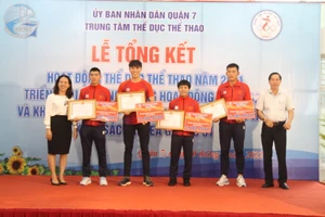 Lãnh đạo quận 7 trao tặng giấy khen cho các vận động viên xuất sắc. Ảnh: NGUYỄN ANH