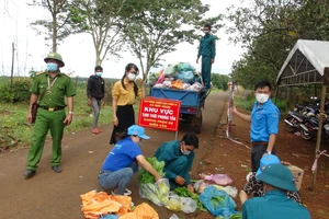 Lực lượng chức năng hỗ trợ đồng bào dân tộc thiểu số ở huyện Bù Gia Mập.