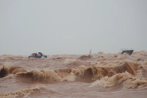 Các thuyền viên tàu Vietship 01 bám trên ống khói trên tàu, vào sáng 10-10. Ảnh: NGUYỄN HOÀNG