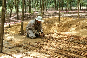 Đội trưởng đội rà phá hiện trường cẩn trọng di chuyển số đạn cối từ dưới hầm lên mặt đất.