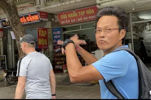  HLV Brad Maloney (đi trước) cùng trợ lý HLV người Malaysia đi bộ ngắm TP Việt Trì sau buổi tập của các học trò. ẢNH: HỮU THÀNH