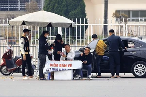 Một nhóm phe vé trước sân Mỹ Đình đã bán được vé "chợ đen" cho người đi ô tô. ẢNH: HỮU THÀNH