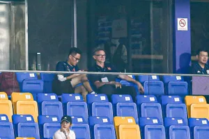 HLV Philippe Troussier cùng phiên dịch viên Hoàng Xuân Bách dự khán trận U22 Malaysia - U22 Lào. ẢNH: TÂM HÀ 