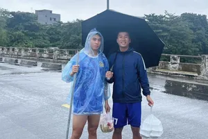 Cầu thủ Huế lội nước đi mua đồ ăn dự trữ. ẢNH: TÂM HÀ 