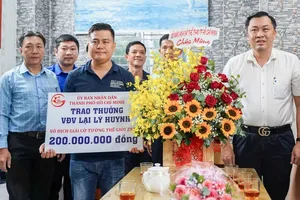Ông Cao Văn Chóng, Phó Giám đốc Sở Văn hóa và Thể thao TPHCM, thừa ủy quyền Ủy ban Nhân dân TPHCM trao 200 triệu đồng tiền thưởng cho kỳ vương Lại Lý Huynh. ẢNH: TÂM HÀ 