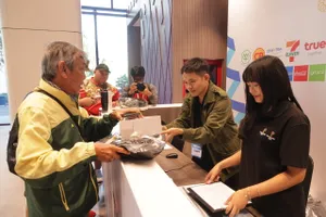 Đội ngũ tình nguyện viên của Ban tổ chức SEA Games 33 hỗ trợ nhà báo Dư Hải nhận thẻ tác nghiệp. ẢNH: DŨNG PHƯƠNG 