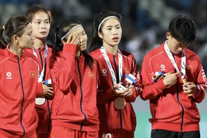 Thái Thị Thảo, Huỳnh Như, Nguyễn Thị Thanh Nhã và Trần Thị Hải Linh thẫn thờ ở bục nhận huy chương. ẢNH: DŨNG PHƯƠNG