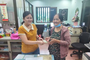 温陵会馆常值副理事长吳丽株向华人贫困家庭发放每月补助金。