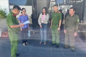 执法人员宣读对阮氏金英的逮捕令。