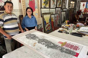 郑钊城与姚金鸾画家展示第二幅义卖作品