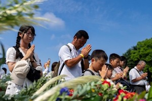 2024年8月6日，在日本广岛举行的遭原子弹轰炸79周年纪念仪式后，人们排队献花，纪念原子弹轰炸受害者 