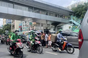 Ngay trước cổng Bệnh viện Bình Dân (quận 3, TPHCM) có cầu vượt bộ hành nhưng người dân vẫn băng qua đường Điện Biên Phủ mà không sử dụng cầu vượt