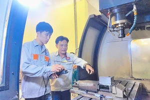 ThS Lê Thành Chung (phải), Trưởng khoa Cơ khí chế tạo, Trường Cao đẳng nghề Vĩnh Phúc, hướng dẫn sinh viên thực hành trên máy CNC